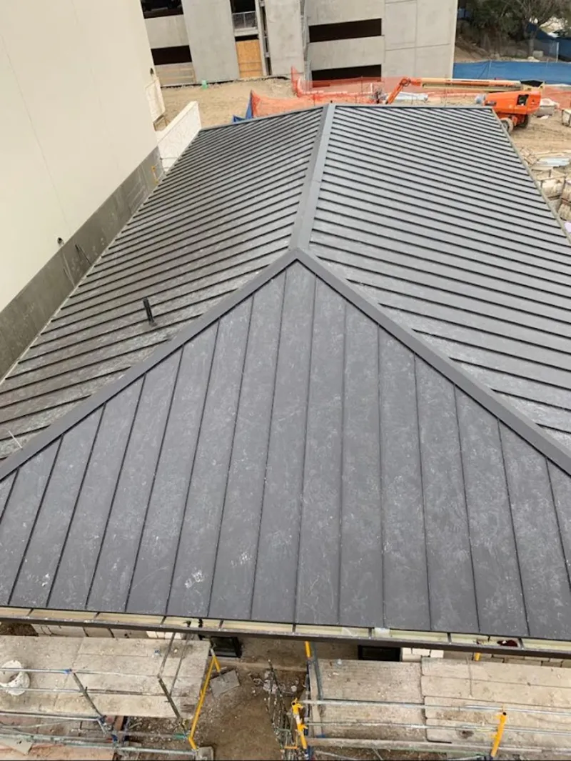 Commercial metal roof construction with crane equipment in Lockport